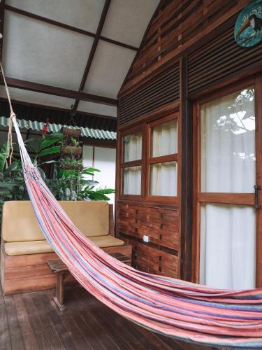 a hammock hanging in a room in a house at Nubá Boutique Hostel Palomino in Palomino