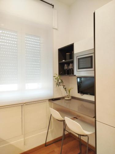 a kitchen with a desk with two chairs and a microwave at Carneval and Tuscany in Viareggio