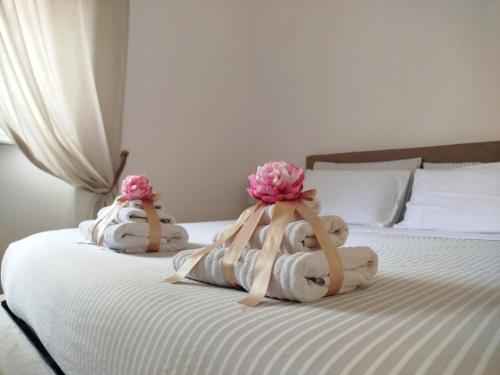 two towels with flowers on top of a bed at Carneval and Tuscany in Viareggio