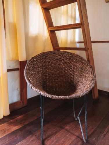 a wicker chair sitting next to a wooden stool at Nubá Boutique Hostel Palomino in Palomino
