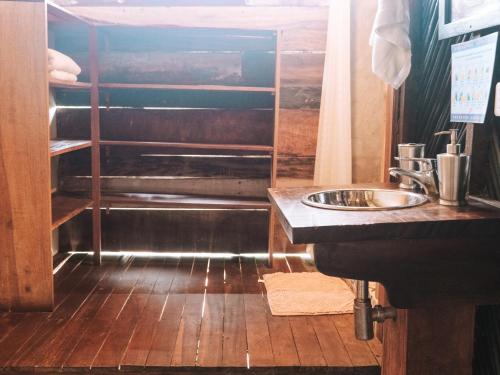 a bathroom with a sink and a wooden floor at Nubá Boutique Hostel Palomino in Palomino