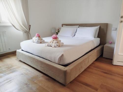 two stuffed animals sitting on a bed in a bedroom at Carneval and Tuscany in Viareggio