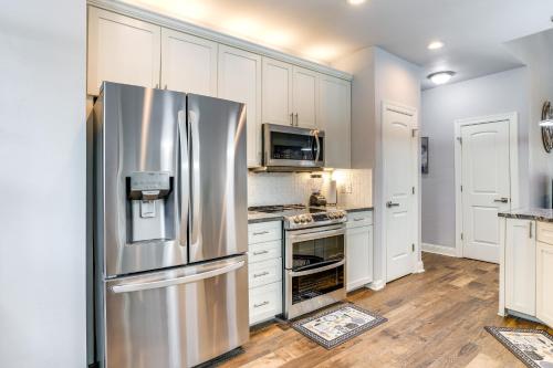 a kitchen with a stainless steel refrigerator and white cabinets at Less Than 1 Mi to Golf and Marina Inviting Home in Afton! in Afton