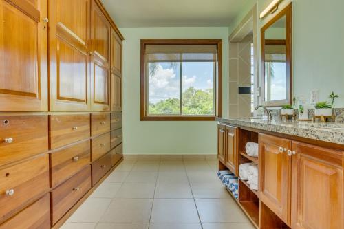 a bathroom with wooden cabinets and a window at The Villas at Cocoplum in Placencia Village