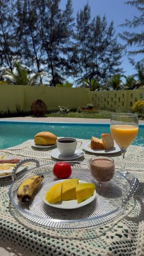 a table with food and a glass of orange juice at Hospedagem Clima Mar in Valença