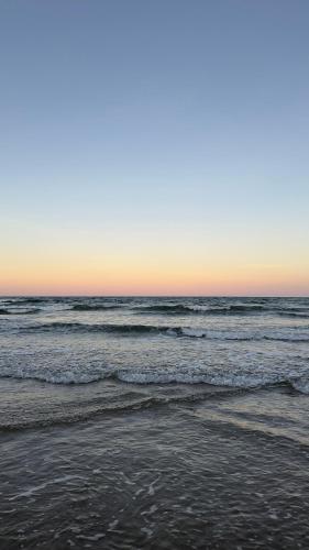 a beach with waves in the ocean at sunset at Hospedagem Clima Mar in Valença