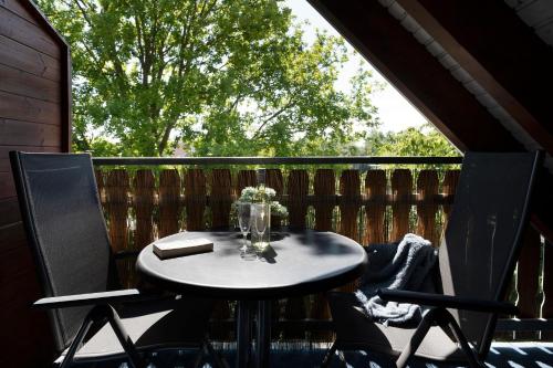 einen Tisch und Stühle auf einer Veranda mit einem Fenster in der Unterkunft Appartementhausanlage Tiemann Bernstein in Kellenhusen
