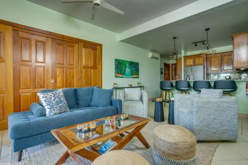 a living room with a blue couch and a table at The Villas at Cocoplum in Placencia Village