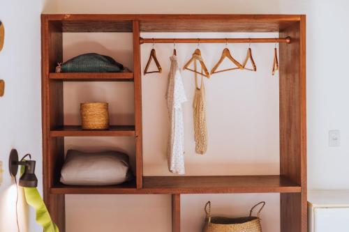 a wooden book shelf with clothes at Pousada Vila das Pedras in Ilhabela