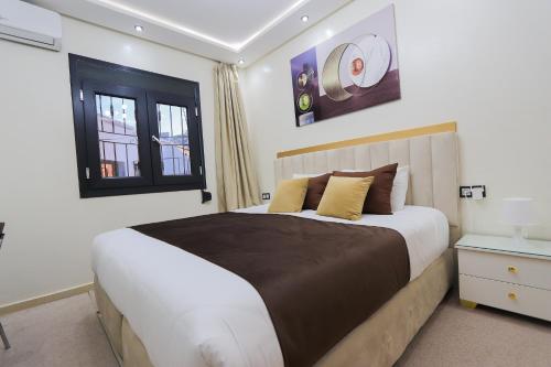 Duplex familial 3 chambres au cœur de la Corniche de Tanger في طنجة: غرفة نوم بسرير كبير ونافذة