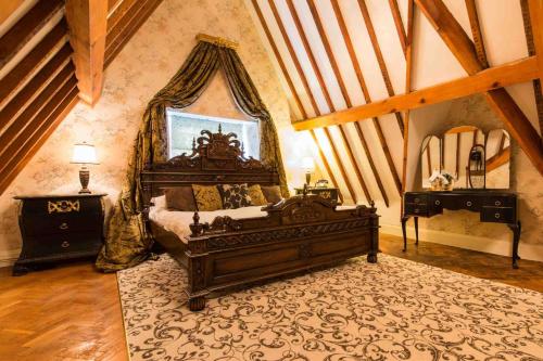 a bedroom with a large wooden bed and a rug at Maenan Abbey Hotel in Llanrwst