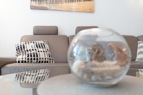 a glass vase sitting on a table in front of a couch at Strandvilla Augustusbad Ostseeparadies in Scharbeutz
