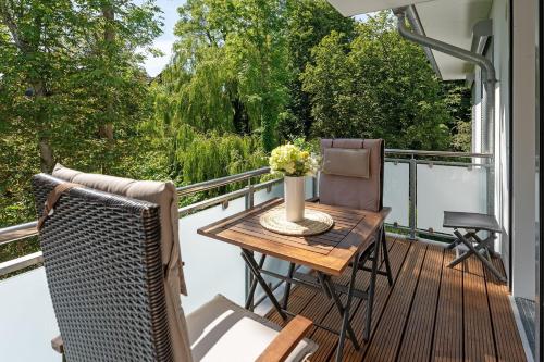 a deck with a table and chairs on a balcony at Strandvilla Augustusbad Ostseeparadies in Scharbeutz