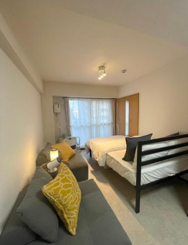 a bedroom with a bed and a couch and a bed at ヤント北大前 in Sapporo