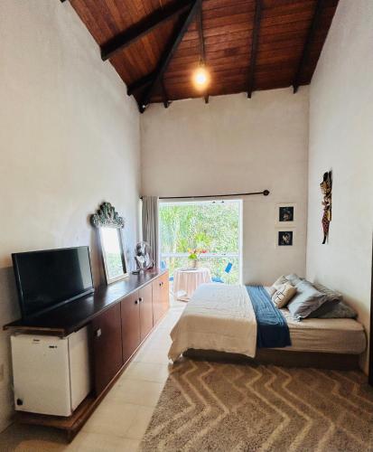 Μια τηλεόραση ή/και κέντρο ψυχαγωγίας στο Quarto em casa de praia com estacionamento