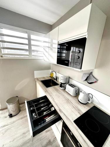 een keuken met een aanrechtblad met een kookplaat en oven bij Azur Studio in Fort-de-France