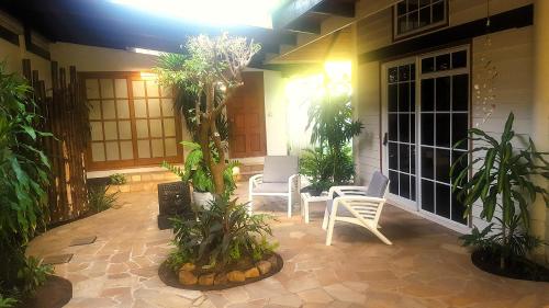 a patio with a table and chairs and plants at MOOREA - Sundara Soul Villa in Hauru