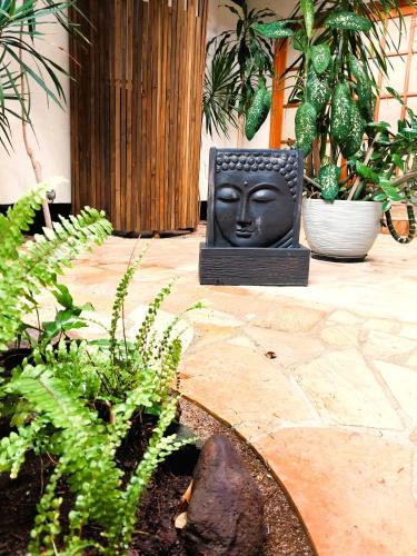 a statue of a face is sitting in a garden at MOOREA - Sundara Soul Villa in Hauru