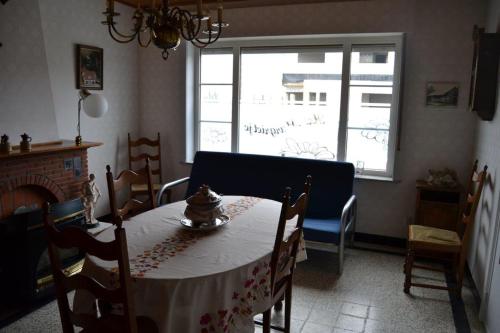 a dining room with a table and a window at Het Margrietje in Merkem