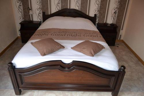 a bed with white sheets and two pillows on it at Het Margrietje in Merkem