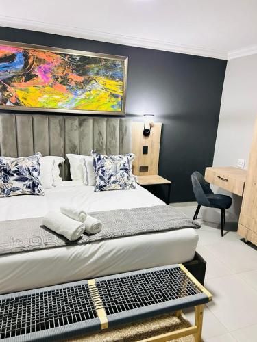 a bedroom with a bed and a painting on the wall at Tranquil Acres in Nelspruit