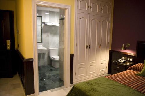 - une chambre avec un lit et une salle de bains avec des toilettes dans l'établissement Hotel Las Acacias, à Puente-Genil