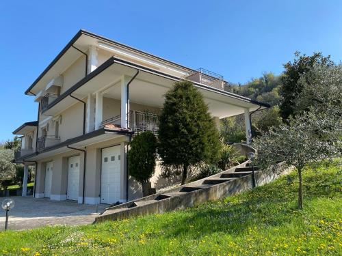a large white house with a driveway and trees at HolidHome - Casa di Francesco in San Giovanni Ilarione