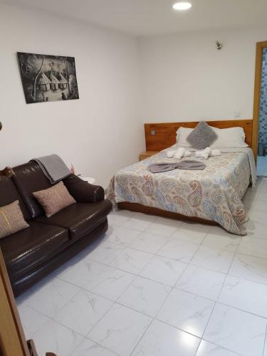 a living room with a couch and a bed at Casa do Vale - Casa da Montanha - Gerês in Geres