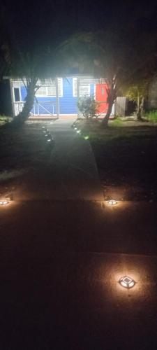 a yard with two trees and lights in the dark at Blue Serenity in Georgetown