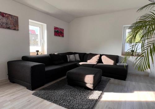 a living room with a black couch and a rug at Ferienwohnung Sonnenblick in Detmold