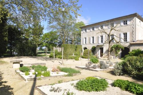 einen Garten vor einem großen Gebäude in der Unterkunft Les Cigales in Charols