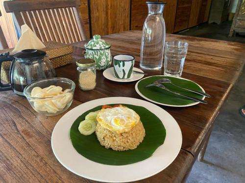 TanjungtirtoにあるOhmmstay - Rumah Pendopoの食べ物の皿が置かれた木製のテーブル