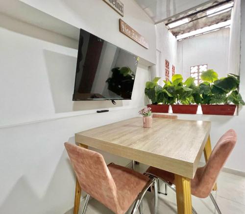 ein Esszimmer mit einem Holztisch und Stühlen in der Unterkunft Increible Apto 10Min Base Aérea - Aquaparque Caña in Cali