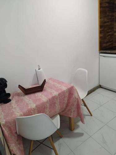 a table with two white chairs and a pink blanket on it at Casa do Vale - Casa da Montanha - Gerês in Geres