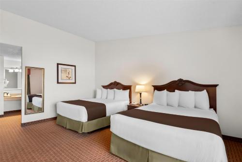 a hotel room with two beds and a mirror at Best Western Chieftain Inn in Wenatchee