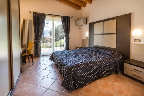 1 dormitorio con cama y ventana grande en Appartamenti Livia, en Gargnano