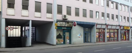 a white building on a city street with stores at City Apartmentstudio mit Tiefgarage free parking in Graz