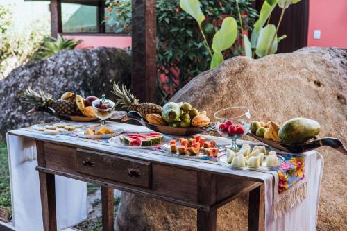 a table filled with fruit and vegetables on a table at Pousada Vila das Pedras in Ilhabela