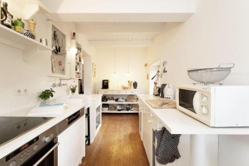 a kitchen with white cabinets and a counter top at Reetdachkate in Gosdorf