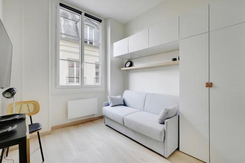 - un salon blanc avec un canapé et un bureau dans l'établissement BUCCI - SAINT GERMAIN Charming apartment, à Paris