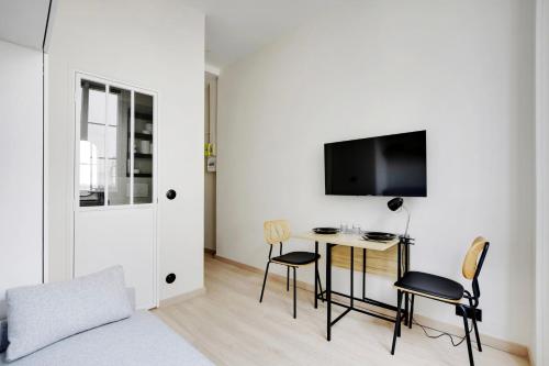 une chambre avec un lit, un bureau et une télévision dans l'établissement BUCCI - SAINT GERMAIN Charming apartment, à Paris