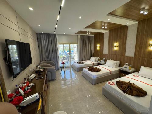 a hotel room with three beds and a flat screen tv at Ramage Hotel & Resort in Cairo