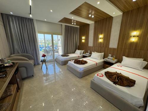 a hotel room with three beds and a couch at Ramage Hotel & Resort in Cairo