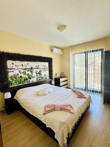 a bedroom with a bed with a large painting on the wall at Апартамент “Централ” / Central in Balchik