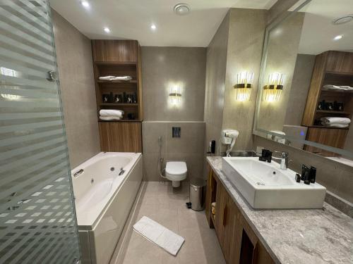 a bathroom with a tub and a sink and a toilet at Ramage Hotel & Resort in Cairo
