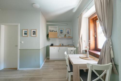 a kitchen and dining room with a table and a refrigerator at Castle Road Bled in Bled