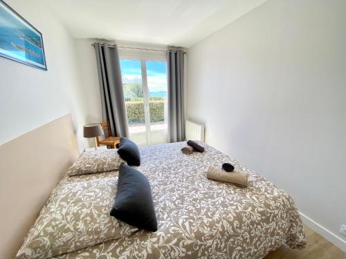 a bedroom with a bed with a large window at Villa Saint Antoine, vue mer à 60m de la plage in Réville