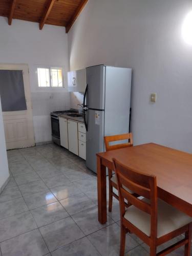 a kitchen with a table and a refrigerator at Tu lugar en Colón in Colón