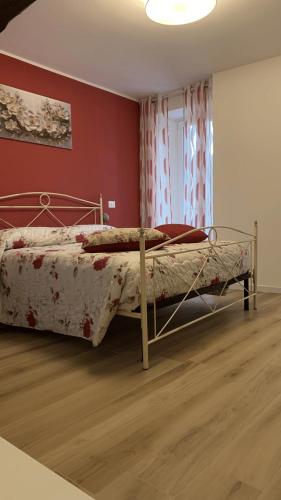 a bedroom with a bed and a red wall at ROSALINDA - Borgo Experience Cilento in Casaletto Spartano