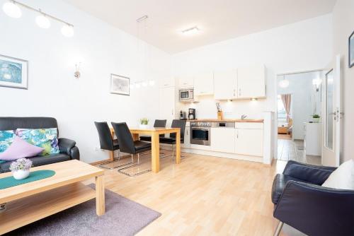 a living room with a table and a kitchen at Villa Olga Wohnung 3 in Grömitz